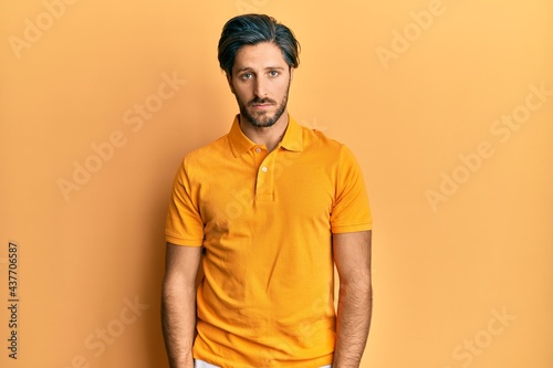 Young hispanic man wearing casual yellow t shirt depressed and worry for distress, crying angry and afraid. sad expression.