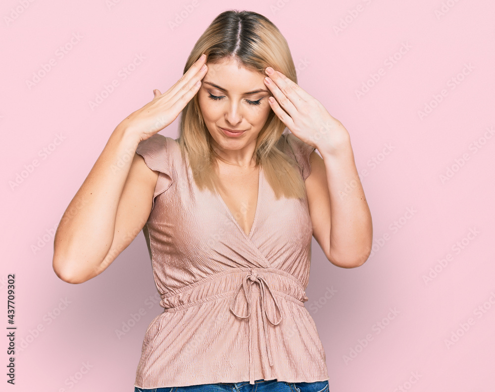 Young caucasian woman wearing casual clothes with hand on head for pain in head because stress. suffering migraine. Young caucasian woman wearing casual clothes with hand on head for pain in head because stress. suffering migraine.
