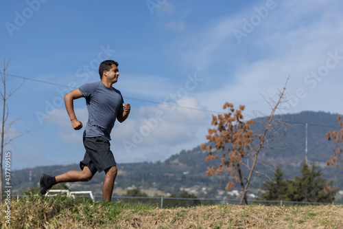 Mexican young man running on a park in mexico