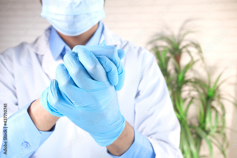 Fototapeta premium man doctor wears medical gloves, close up