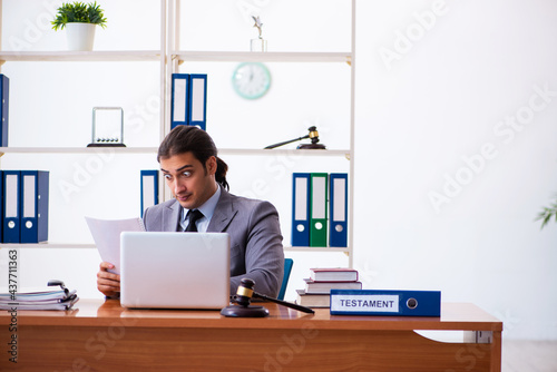 Canvas Print Young male lawyer sitting in the office
