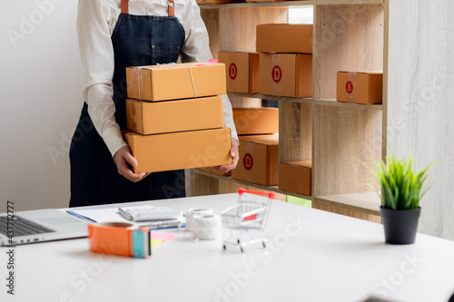 Close uo of female start up small business owner writing address on cardboard box at workplace.small business entrepreneur SME , working with box at home, Online selling, e-commerce, packing concept