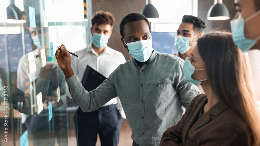 Workers in masks having meeting using sticky post-it notes Workers in masks having meeting using sticky post-it notes