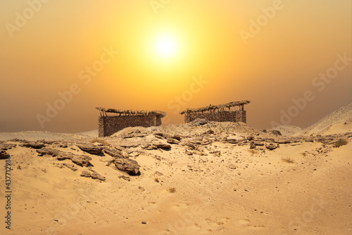 Small huts in the middle of the desert with an amazing landscape background. Desert stone hut. dust storm.