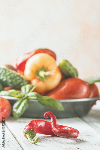Red hot peppers with vegetables on white wooden background