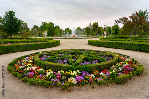 Gardens with colorful flowers and shrub hedges in the royal palace of Aranjuez.