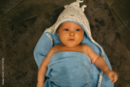 baby lies in a towel after a bath