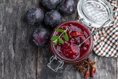 Vászonkép Homemade plum chutney in glass jar on wooden table