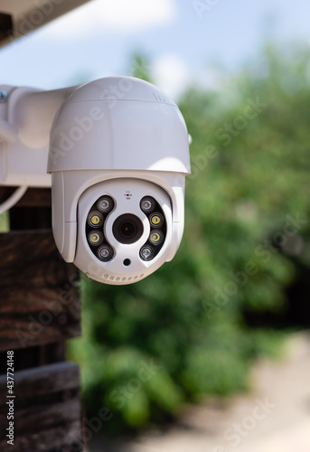 IP CCTV wifi surveillance camera on backyard background. Concept of home security technology. vertical image