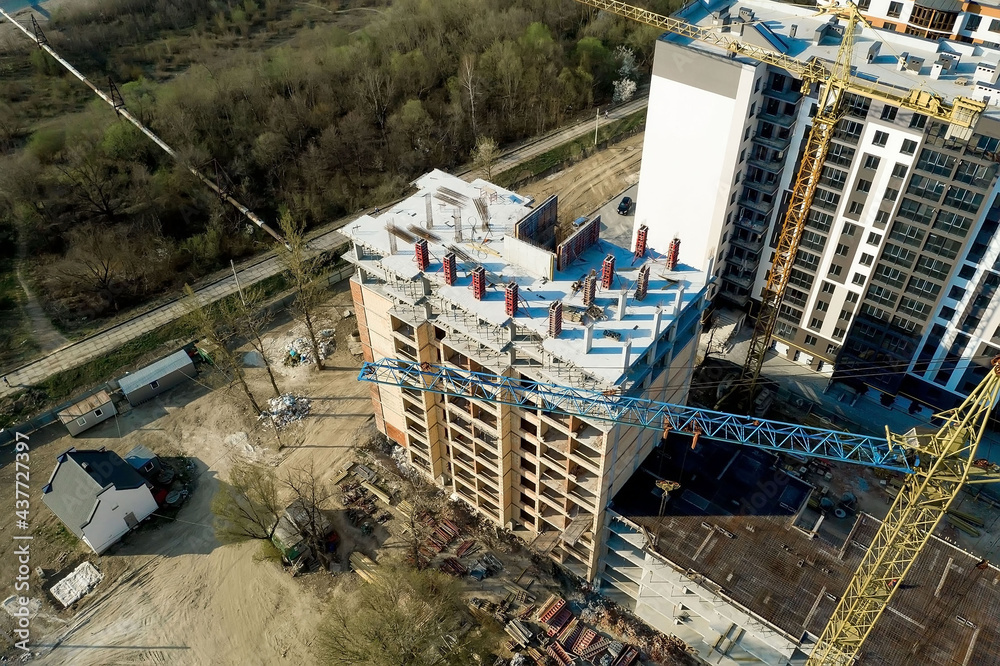 Fototapeta premium Construction and construction of high-rise buildings, the construction industry with working equipment and workers. View from above, from above. Background and texture