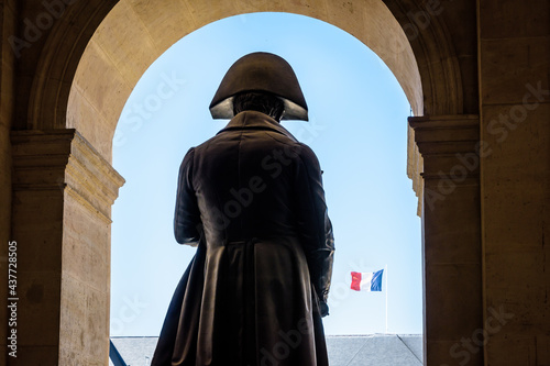 Rear view of the statue of Napoleon Bonaparte in the Hotel des Invalides in Paris, France, with french flag