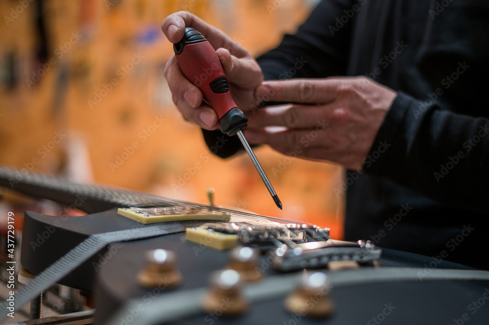 Fototapeta premium Guitar in repair service shop with a hands of a guitar luthier