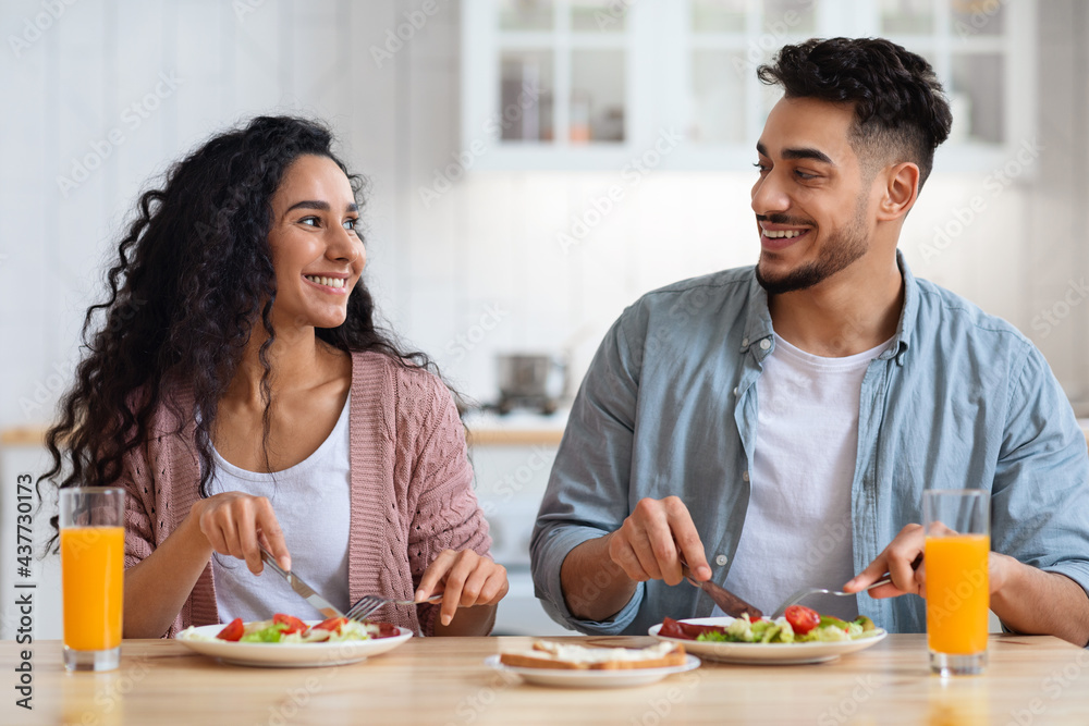 Romantic middle-eastern couple having healthy breakfast together in kitchen at home