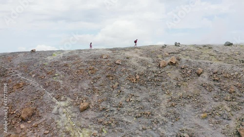 Aerial landscape of Aeolian Islands. scenic view from drone flying over volcano crater with people silhouette walking trough sulfuric smokes. Volcano Island travel destination in Sicily. Aerial pan photo