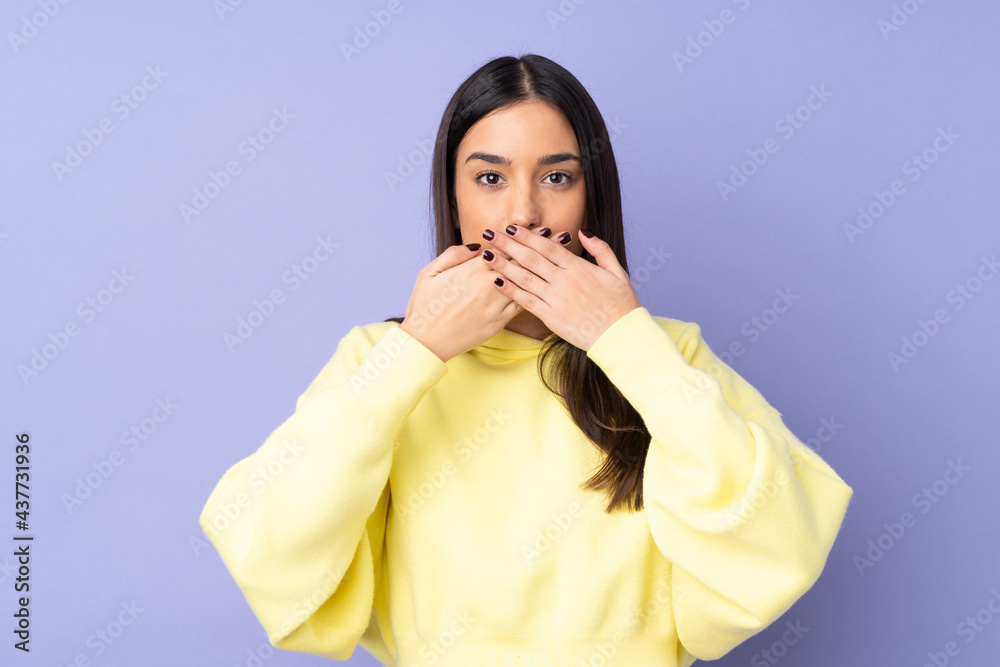 Young caucasian woman over isolated background covering mouth with hands Young caucasian woman over isolated background covering mouth with hands