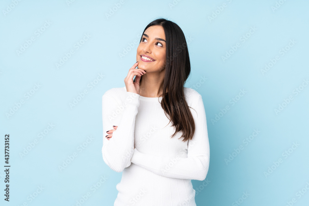 Young caucasian woman isolated on blue background thinking an idea while looking up Young caucasian woman isolated on blue background thinking an idea while looking up