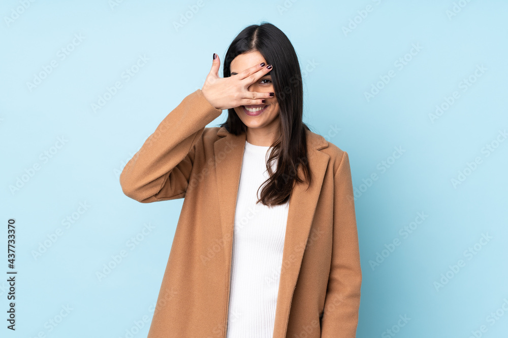 Young caucasian woman isolated on blue background covering eyes by hands and smiling Young caucasian woman isolated on blue background covering eyes by hands and smiling