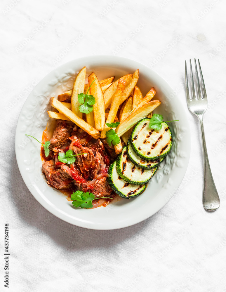 Slow cooker beef stew with grilled zucchini and french fries on a light background, top view Slow cooker beef stew with grilled zucchini and french fries on a light background, top view