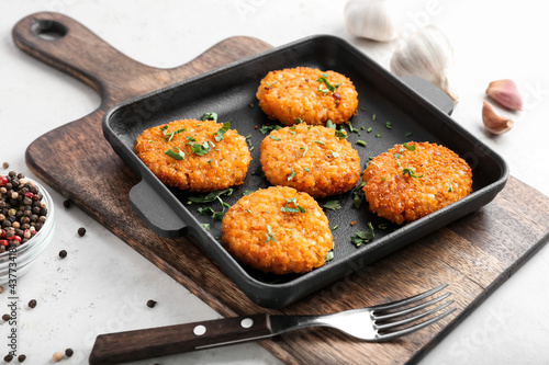 Frying pan with tasty lentil cutlets on table photo