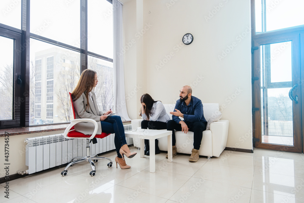 A young married couple of men and women talk to a psychologist at a therapy session. Psychology. A young married couple of men and women talk to a psychologist at a therapy session. Psychology.