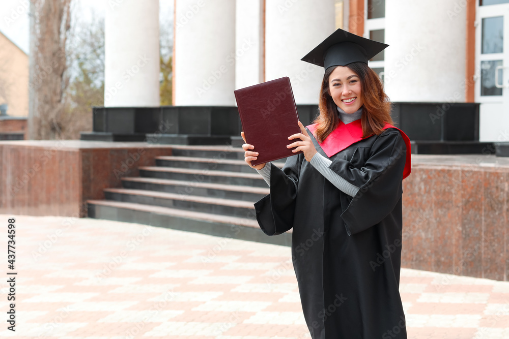 Female student in bachelor robe and with book on her graduation day Female student in bachelor robe and with book on her graduation day