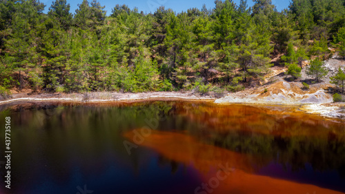 Shore of toxic red lake in abandoned open pit mine. Its color derives from high levels of acid and heavy metals