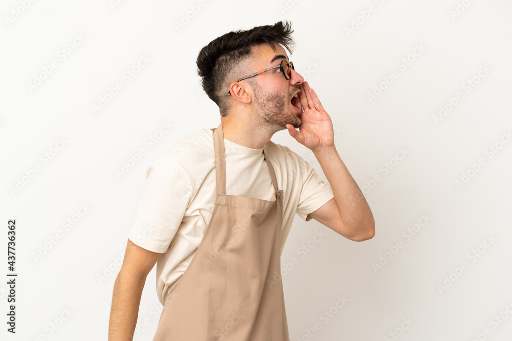Restaurant waiter caucasian man isolated on white background shouting with mouth wide open to the lateral Restaurant waiter caucasian man isolated on white background shouting with mouth wide open to the lateral