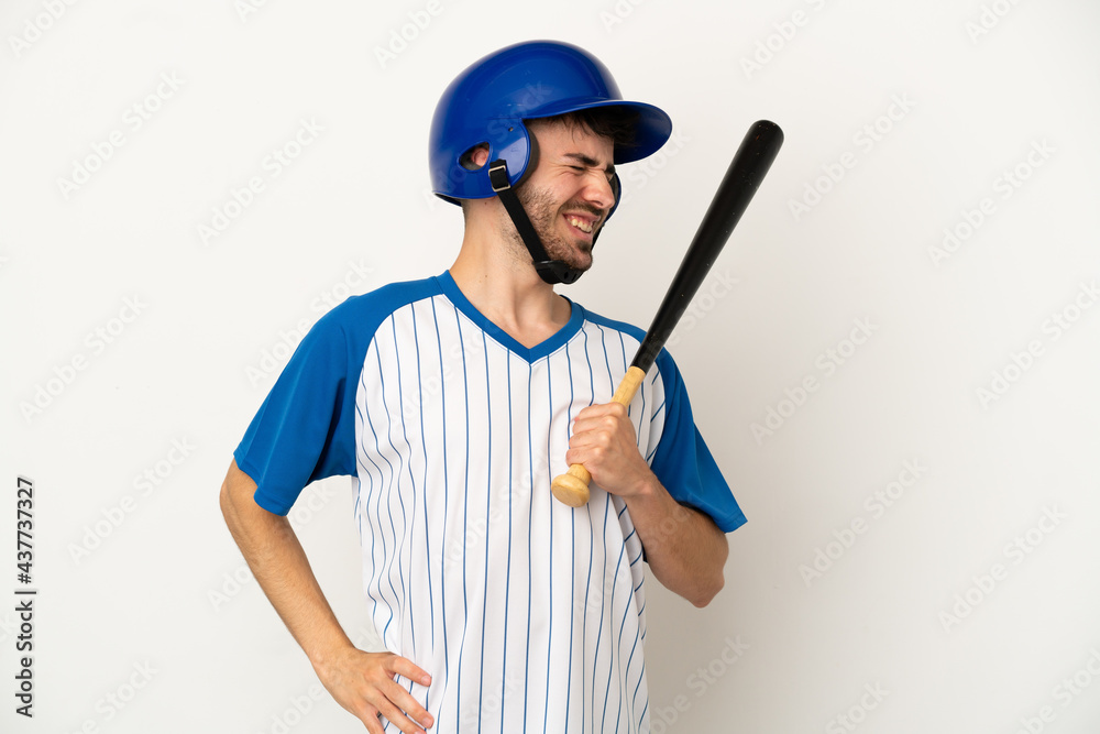 Young caucasian man playing baseball isolated on white background suffering from backache for having made an effort Young caucasian man playing baseball isolated on white background suffering from backache for having made an effort