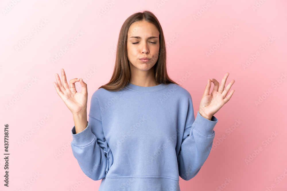 Young woman over isolated pink background in zen pose Young woman over isolated pink background in zen pose