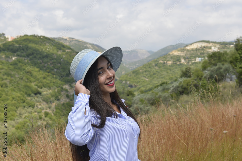 Young woman smiling. Beautiful girl portrait. Close up on face. Valley and mountains