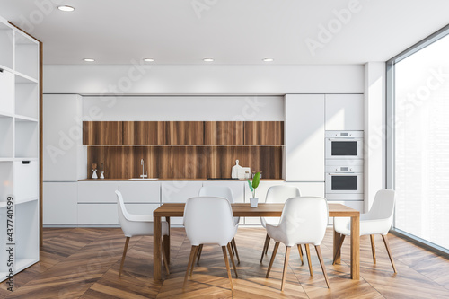 Dining table in white and wooden kitchen interior