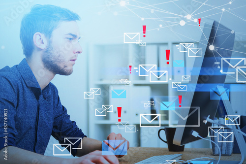 Businessman in front of the computer, hologram of mails and network circuit photo