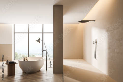 Bathtub and shower in light bathroom interior with window and wooden floor