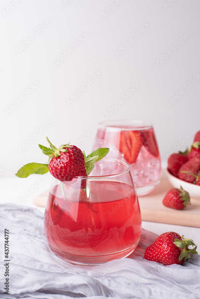 Glasses with refreshing strawberry lemonade and strawberries on white background, summer fruit drinks concept. Glasses with refreshing strawberry lemonade and strawberries on white background, summer fruit drinks concept.
