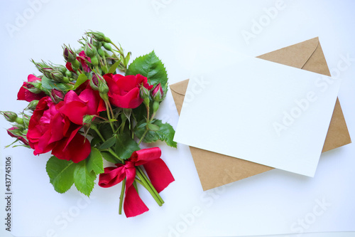 Fototapeta Naklejka Na Ścianę i Meble -  postcard mockup. small bouquet of red roses on a white background and place for text 