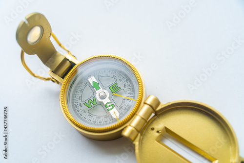 Banner of golden compass isolated, shallow DOF, focus on dial. Compass on a white background. Concept for direction, travel, guidance or assistance.