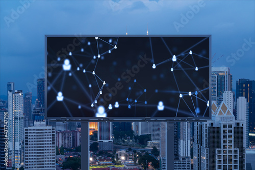 Glowing Social media icons on billboard over night panoramic city view of Kuala Lumpur, Malaysia, Asia. The concept of networking and establishing new connections between people and businesses in KL