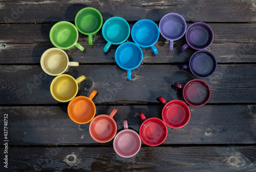 Pride coffee mug arrangement, with a rainbow of colors in a heart shape