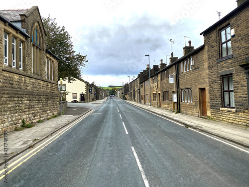Looking along, Huddersfield Road, with old stone built houses, on a cloudy day in, Newhey, Rochdale, UK