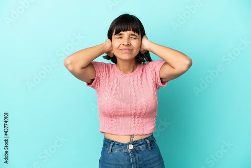 Young mixed race woman isolated on blue background frustrated and covering ears