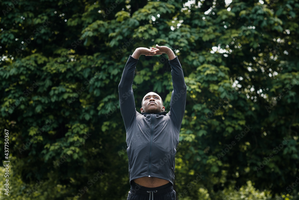 Portrait of black male athlete stretching in a park. Portrait of black male athlete stretching in a park.