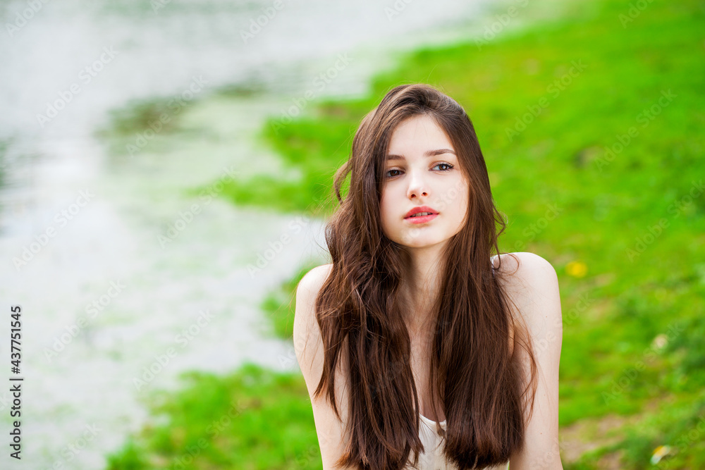 Portrait of a young beautiful brunette girl posing in summer park Portrait of a young beautiful brunette girl posing in summer park