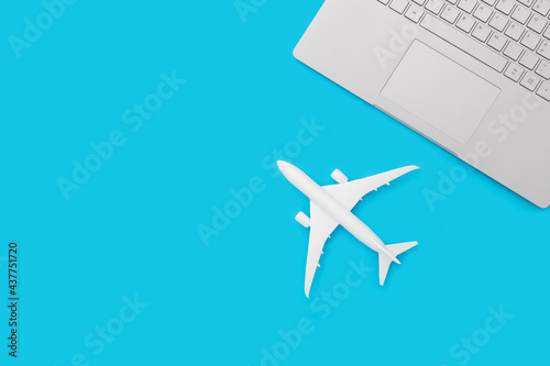 Toy airplane and notebook keyboard on pastel blue background. Flat lay design © Drpixel