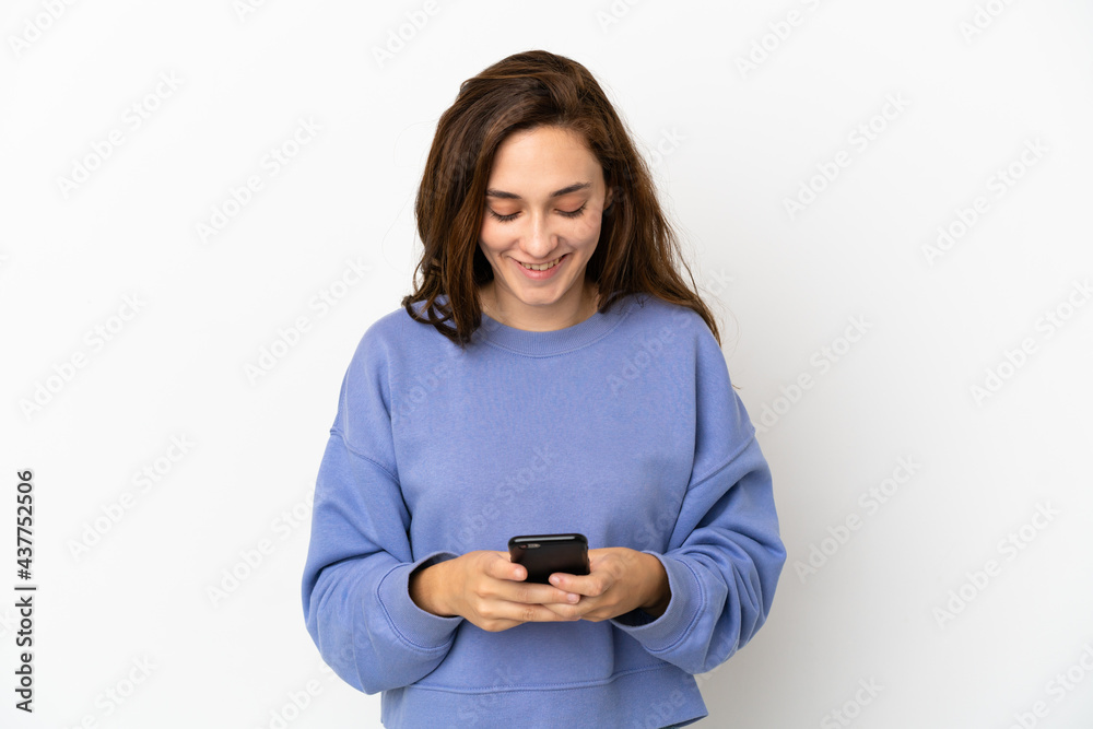 Young caucasian woman isolated on white background sending a message with the mobile Young caucasian woman isolated on white background sending a message with the mobile