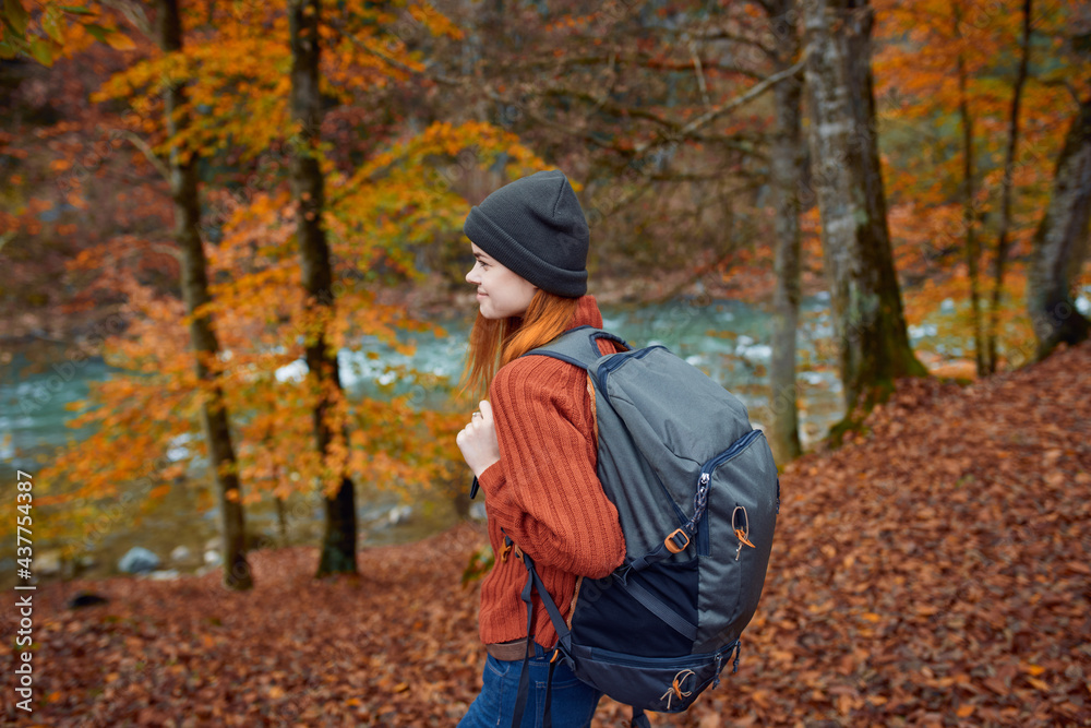 woman hiker walks in the forest in autumn in nature near the river and leaves landscape woman hiker walks in the forest in autumn in nature near the river and leaves landscape