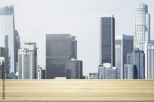 Empty wooden tabletop with beautiful Los Angeles skyscrapers at daytime on background  mock up