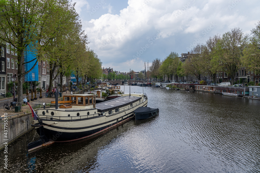 cityscape view of Amsterdam with many historic buildings lining the sides of the Amstel canal