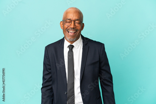 Business senior man isolated on blue background laughing in lateral position