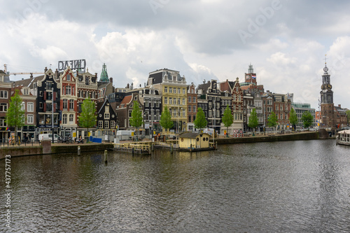 cityscape view of Amsterdam with many historic buildings lining the sides of the Amstel canal © makasana photo