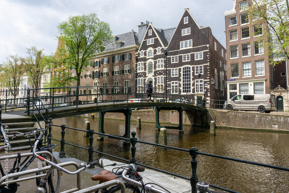 cityscape view of Amsterdam with many historic buildings lining the sides of the Amstel canal